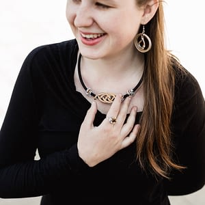 smějící se dívka s prořezávaným náhrdelníkem a náušnicemi z kapslí